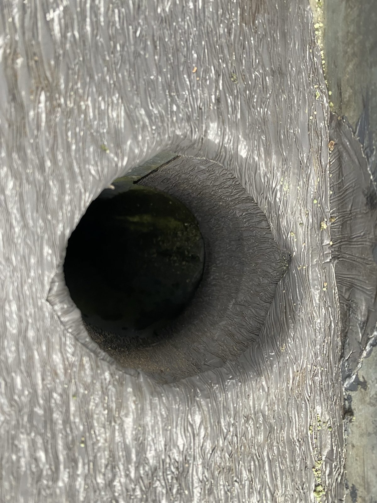 Close-up van een zinken dakgoot bij de afvoer